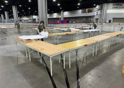 Members of Courtesy Corps covering tables with paper